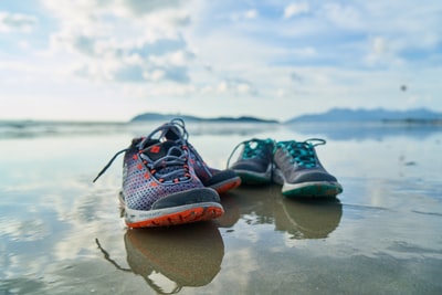 During the day in brown dressed in blue and black Nike sports shoes on the beach
